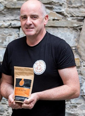 Picture of Sean McGloin holding a pack of Blakes coffee beans